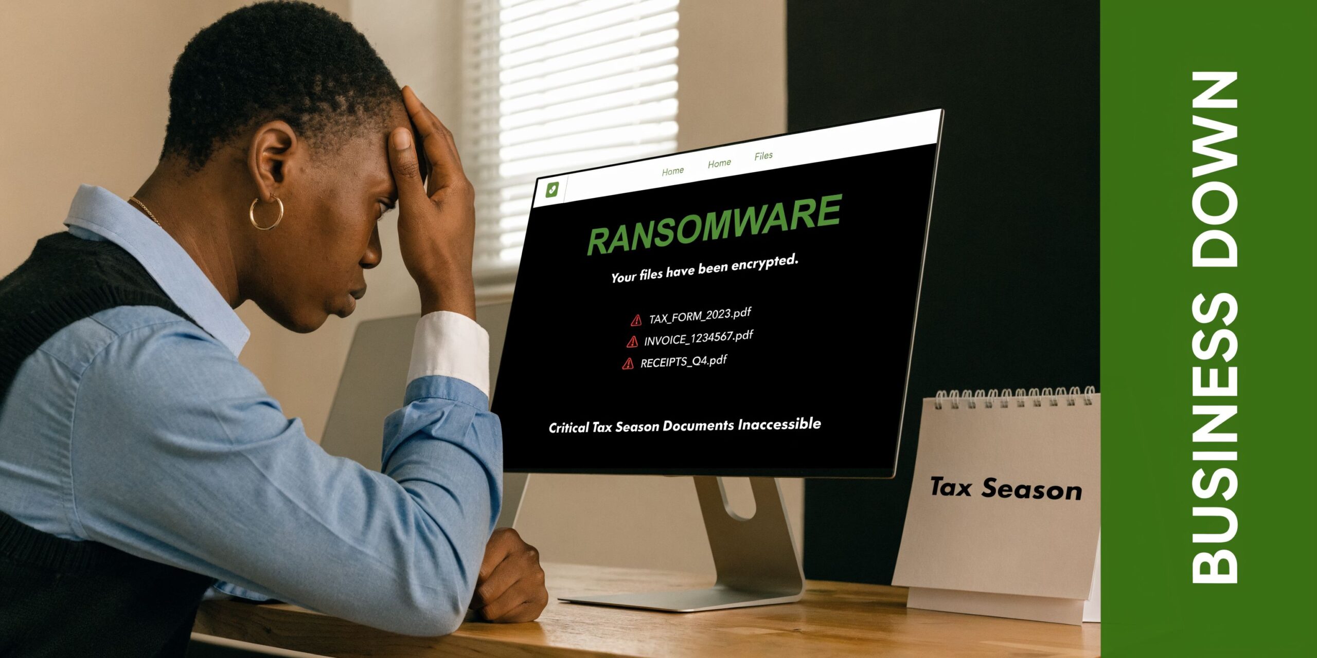 A person sitting at a desk appearing distressed while looking at a computer screen displaying a ransomware alert.