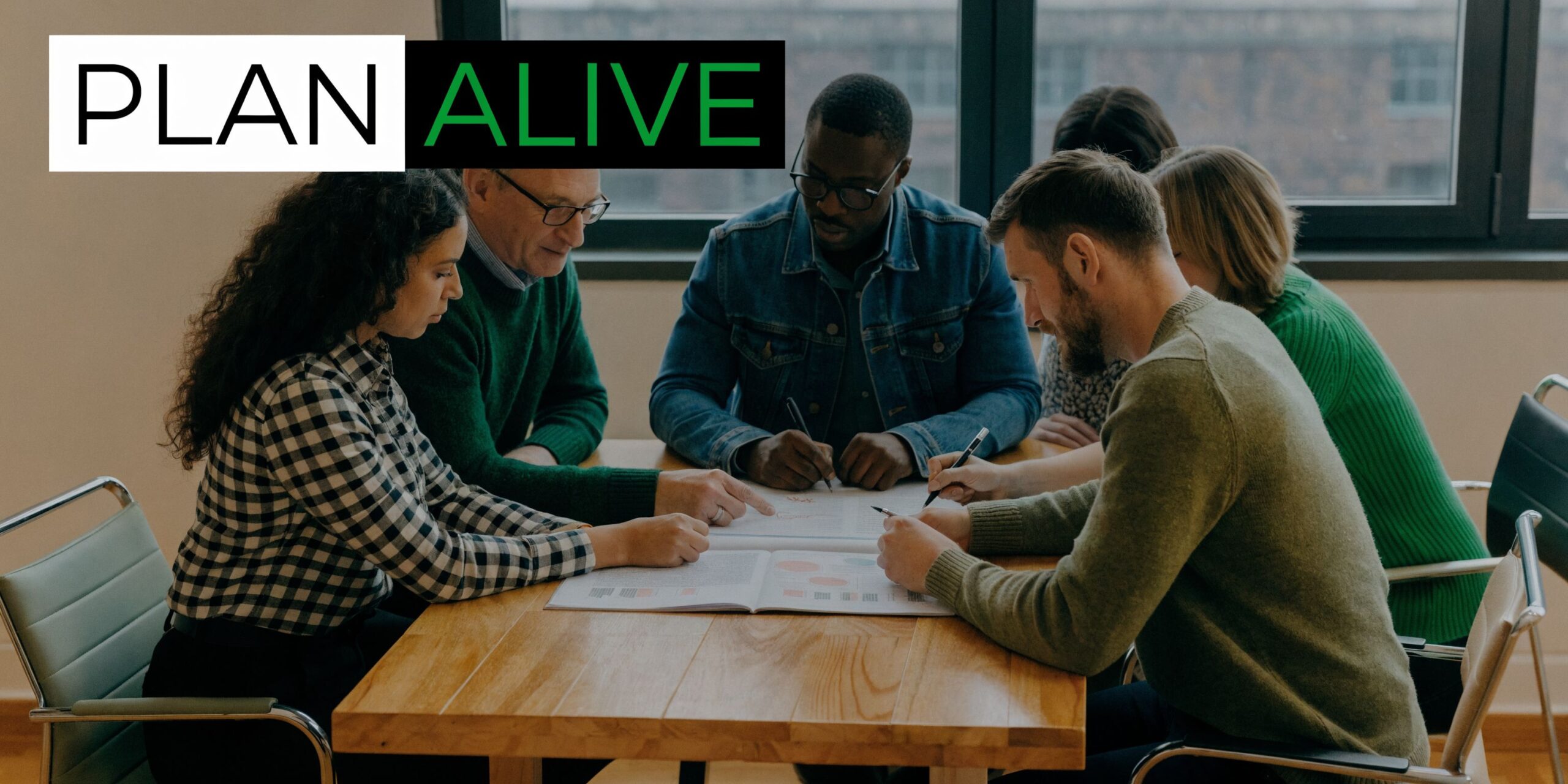 A diverse team of professionals collaboratively working together around a wooden table in an office setting.