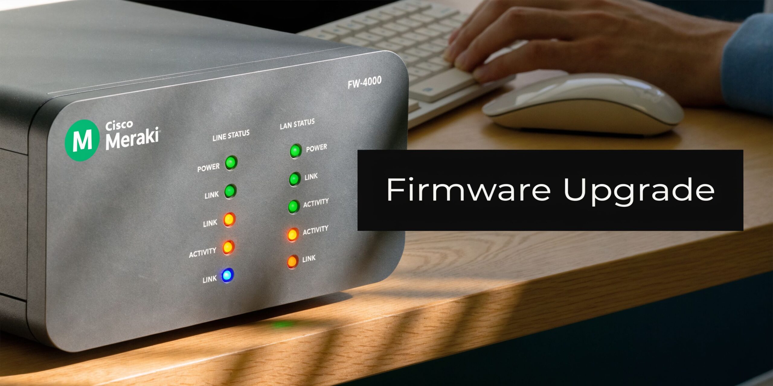 A Cisco Meraki FW-4000 network device with active status lights on a desk during a firmware upgrade.