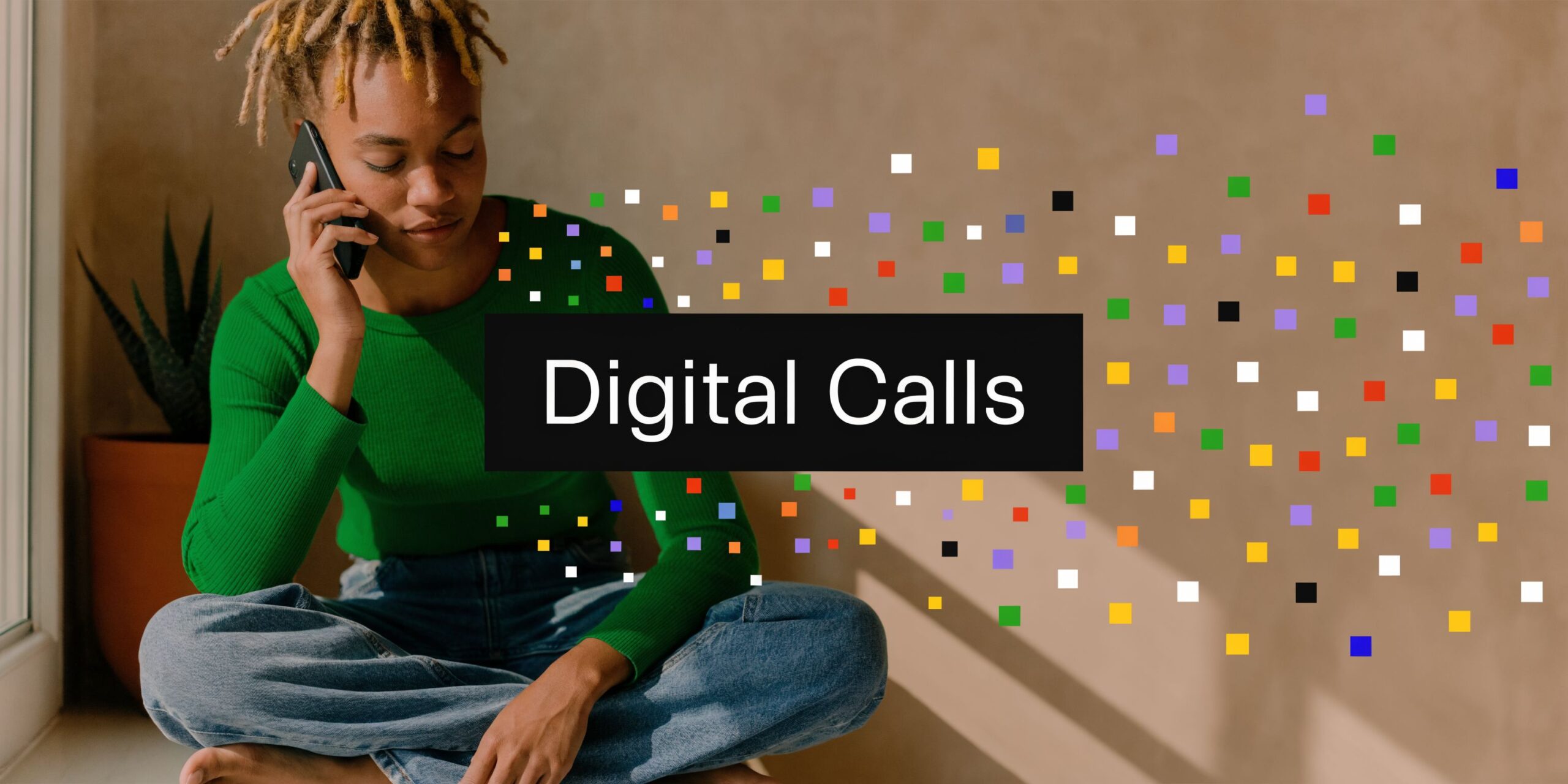 A person with locs sits cross-legged while talking on a smartphone, surrounded by colorful digital pixel icons.