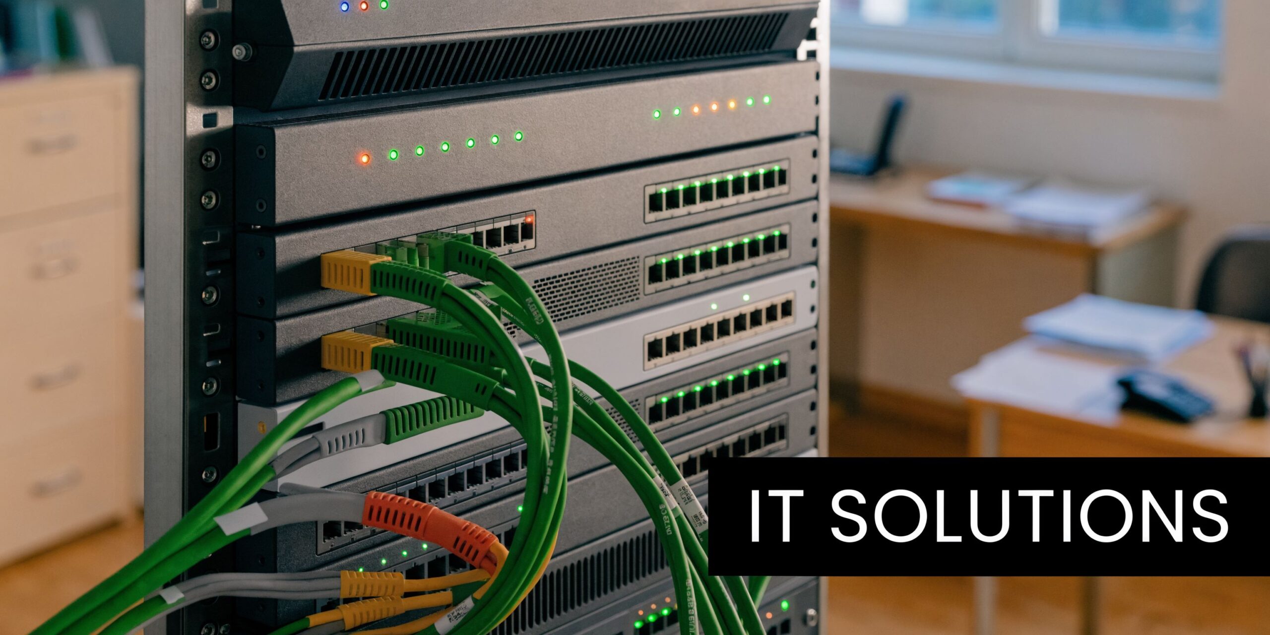 A close-up view of a rack-mounted network server with many green and orange cables connected to ports.